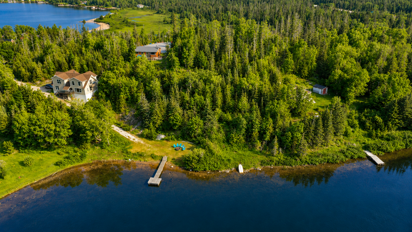 Waterfront living at its finest! This incredible 6 bedroom retreat on 1.25 private acres features two kitchens, two living rooms, a private beach with dock, and endless opportunities for year-round adventure. 2