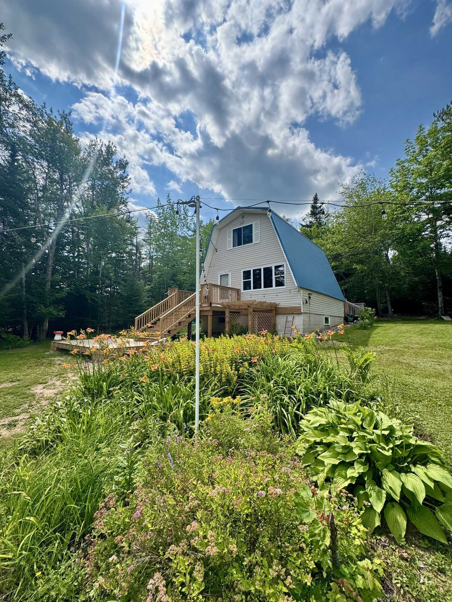 East Dalhousie four season cottage with lake frontage ideal for boat launch! 60x40 field with 200amp wired mini barn, 12x12 geodesic all-season dome, outdoor shower, and new front & back decks- your ideal lakeside retreat! 2