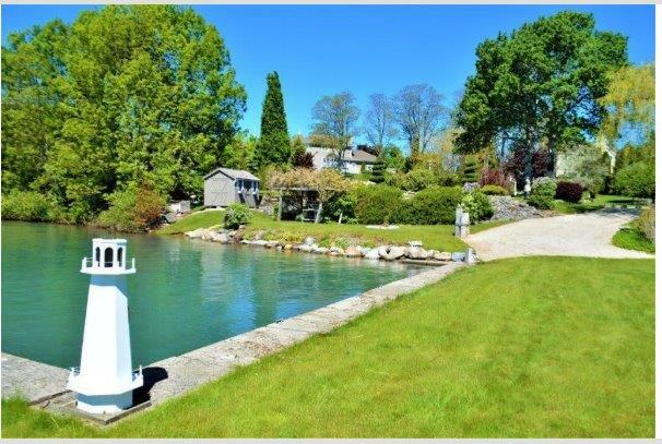 VTB MORTGAGE AT BELOW MARKET RATES on Georgian Bay waterfront property with Pier and Concrete Dock located in prestigious Sutacriti Park.   Manicured landscaping with Pond.  Nearly 3400 sq ft of luxury living space with separate entry In-law Suite. 4